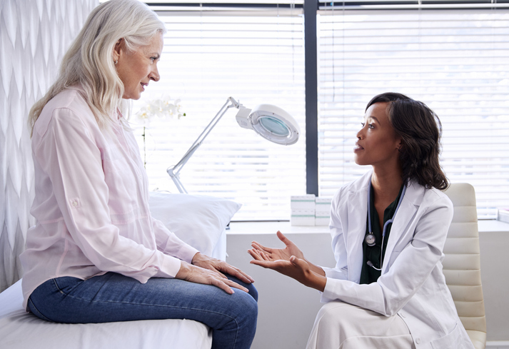 Mature Woman In Consultation With Female Doctor Sitting In Office