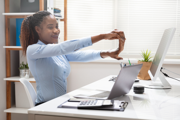 Woman stretching her arm at her desk