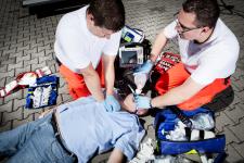 Two male EMS workers helping an injured patient