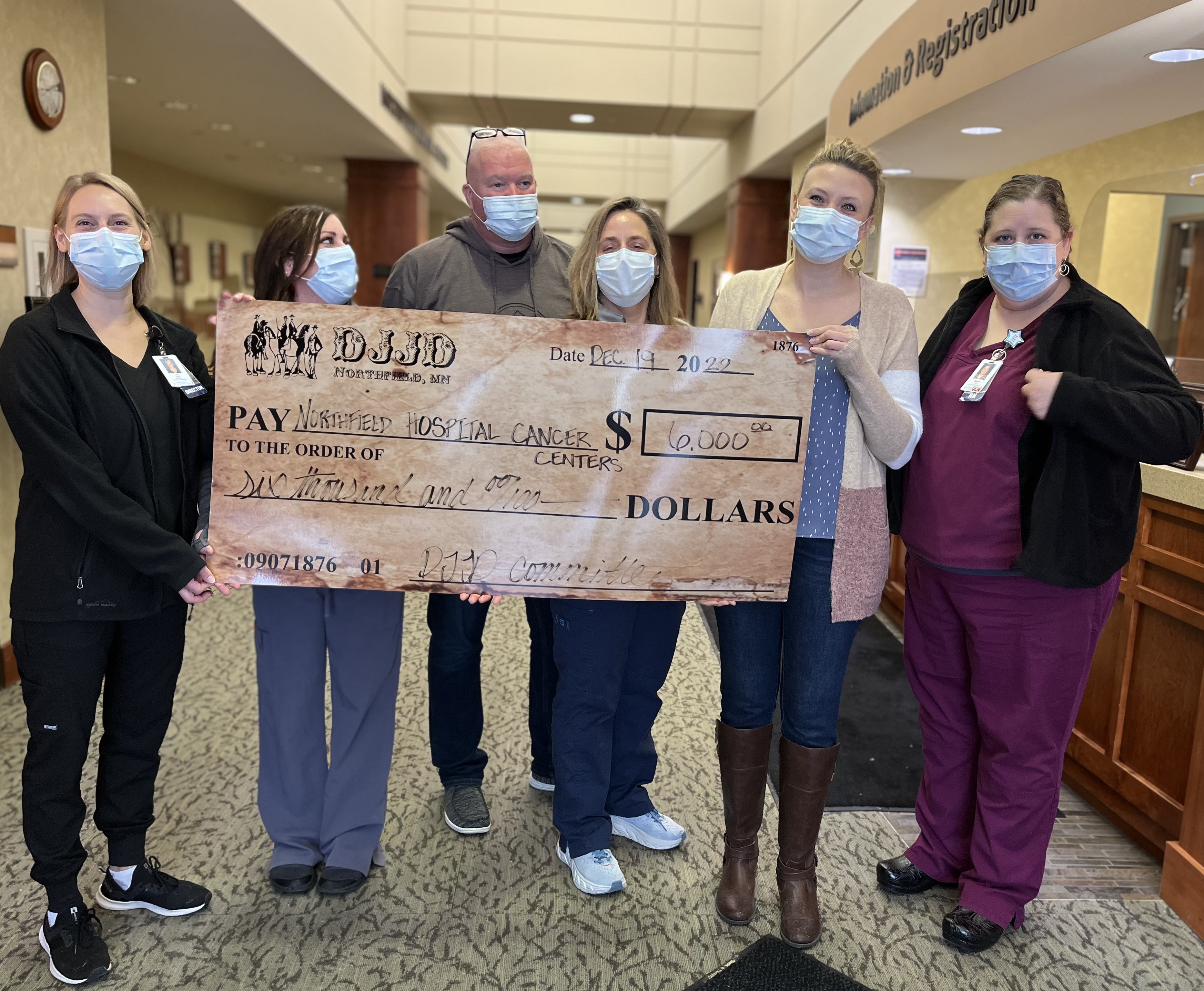 group of health care workers holding large check