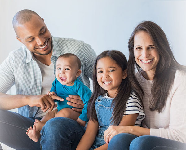 smiling young family of two parents and two young children