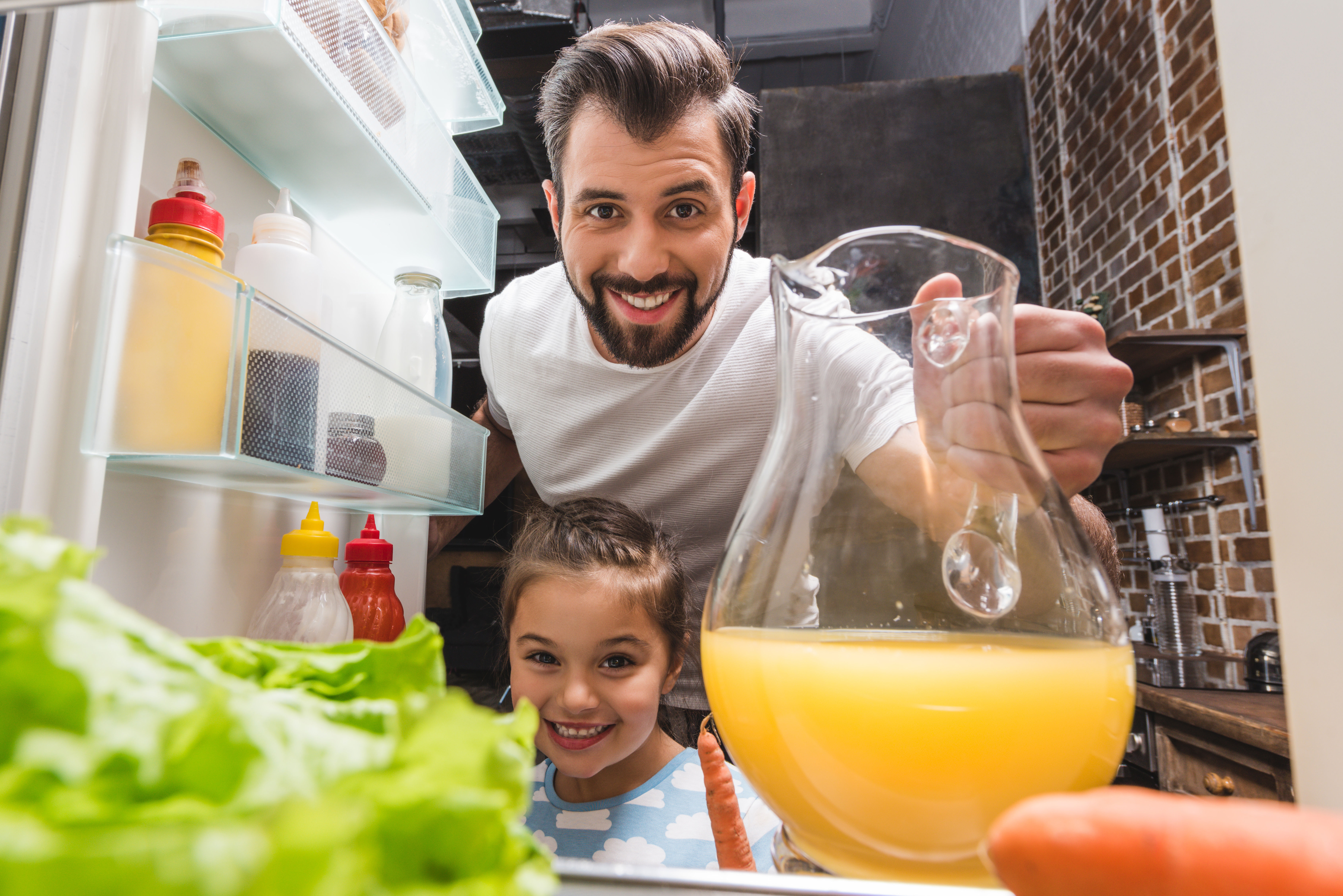 Father and daughter looking into fridge
