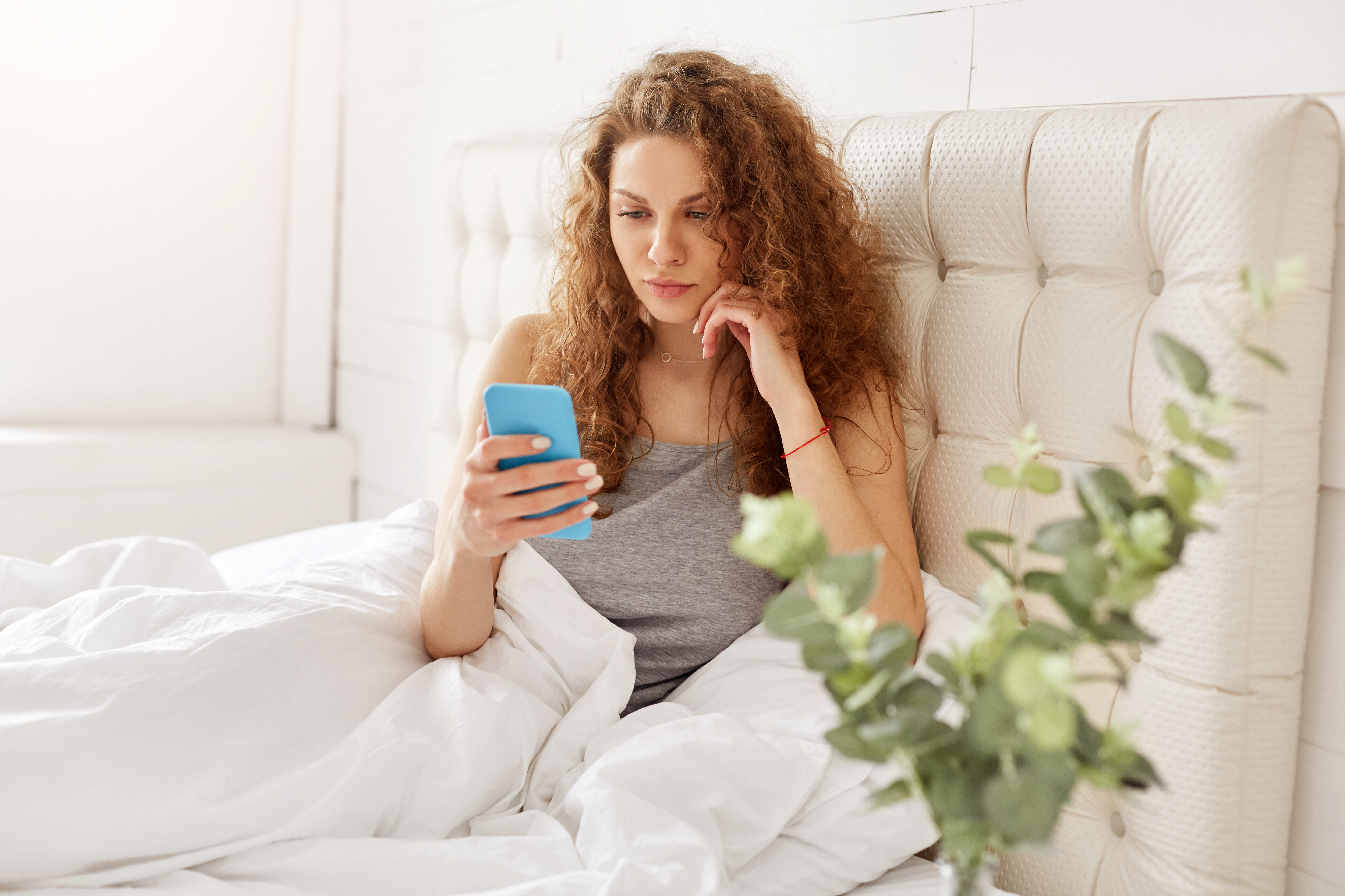 Woman in bed on phone