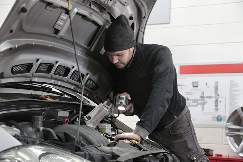 Man working under the hood of a vehicle 