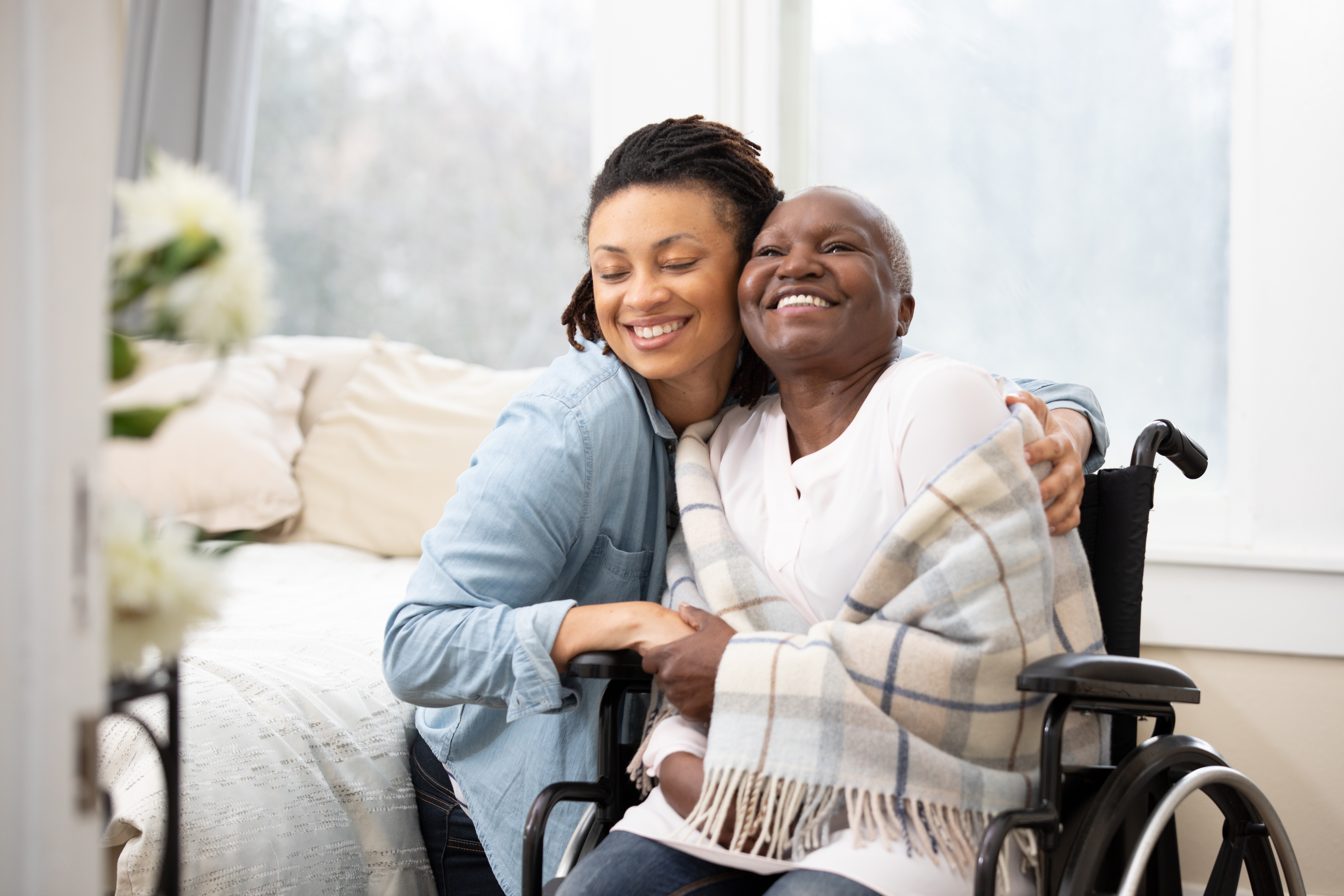 Woman hugging woman in wheel chair 