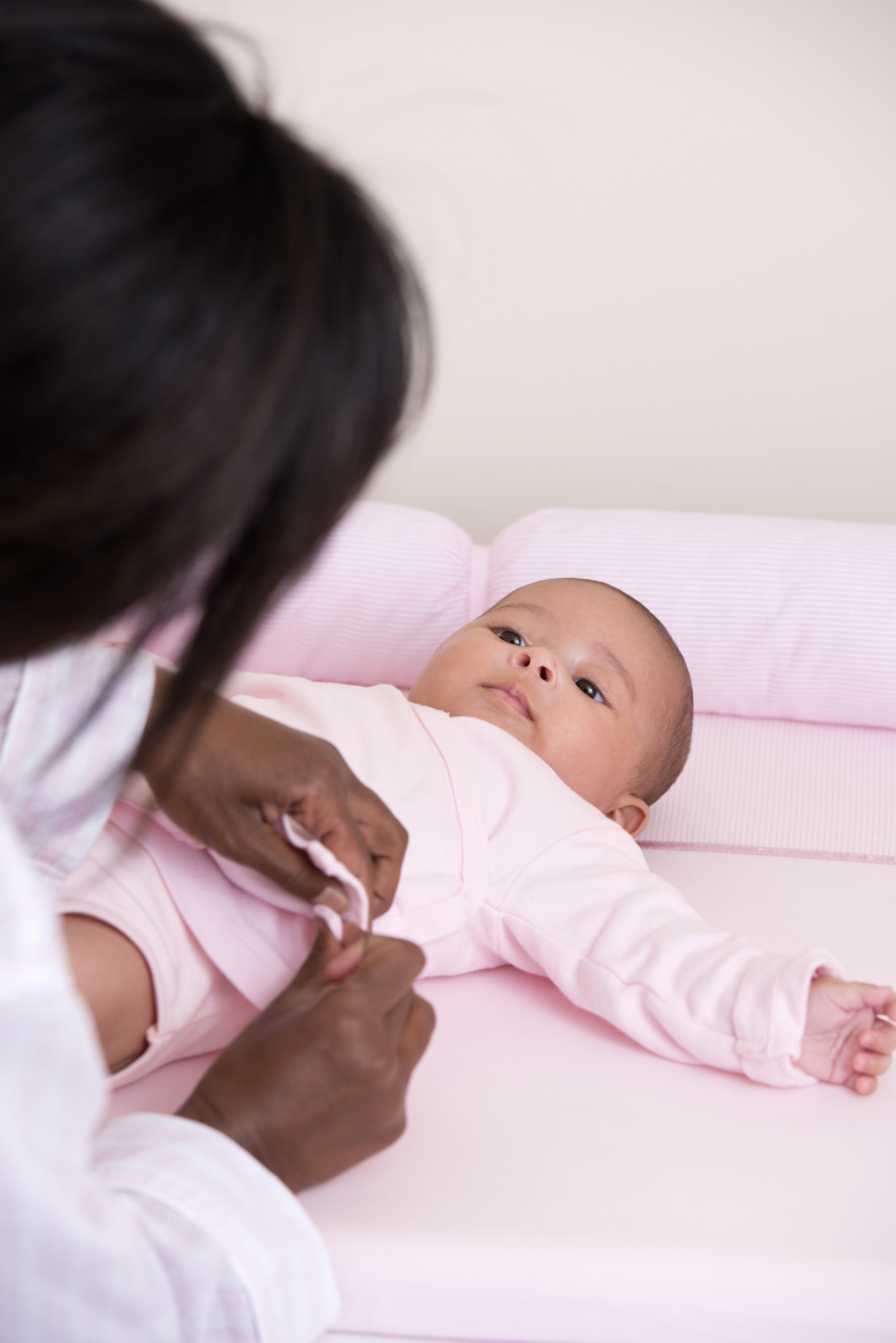 A mother dressing a baby. 