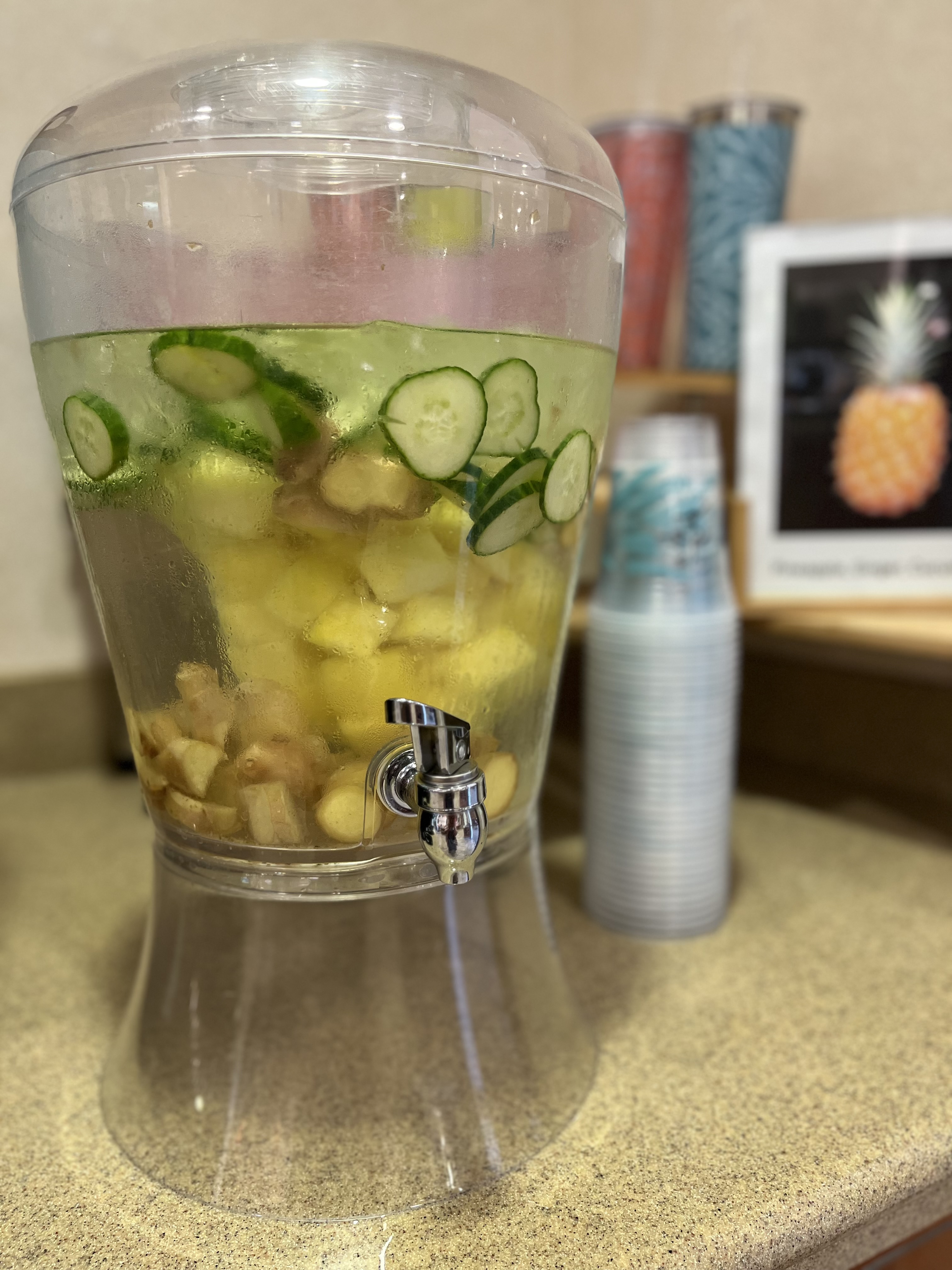 Clear pitcher of water with cucumbers and lemons floating in it.