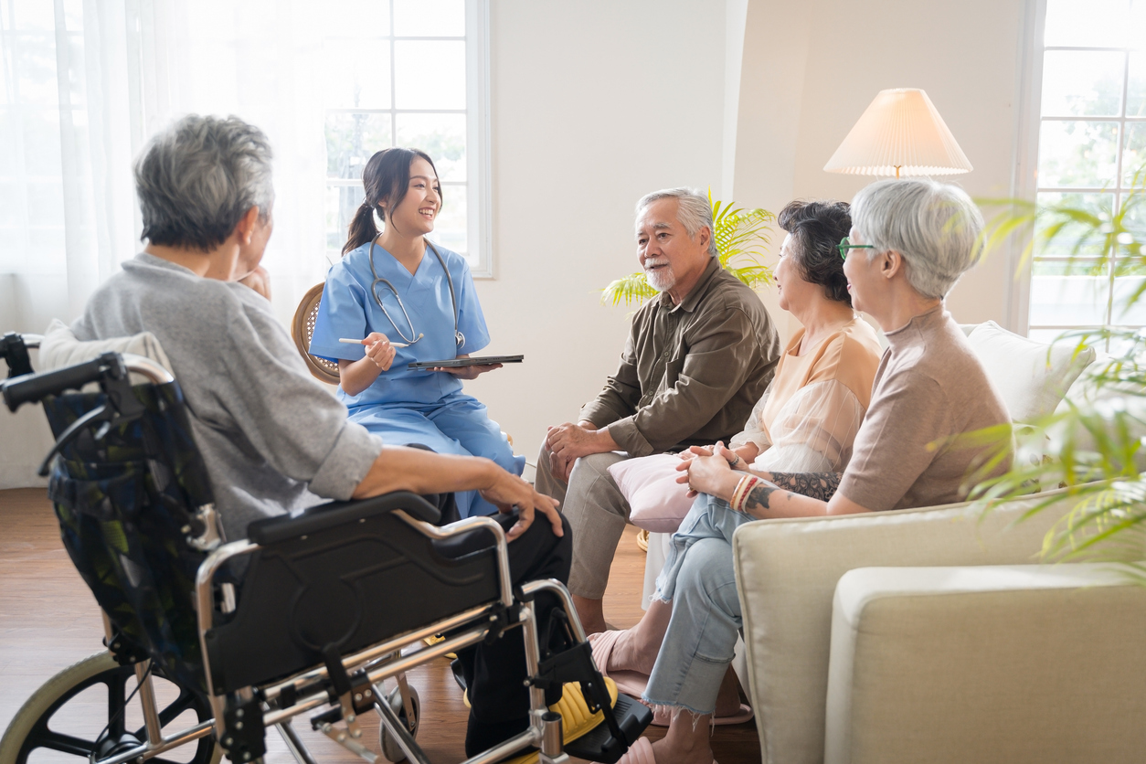nurse talking to elderly patient and family
