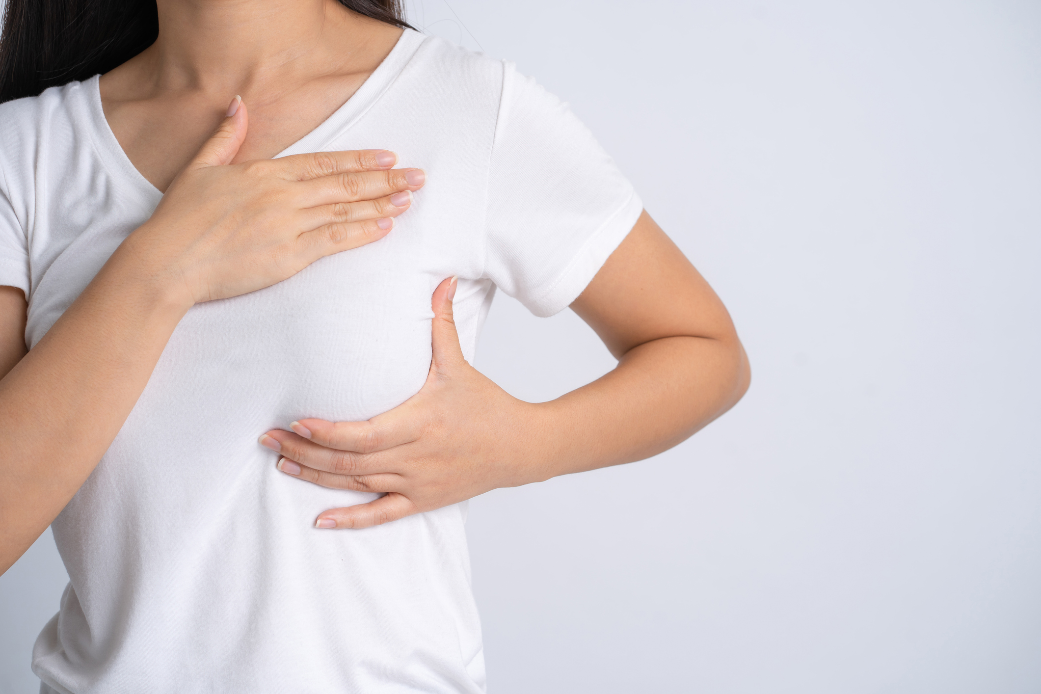 woman giving herself a self breast exam