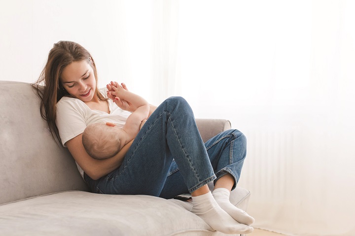 Smiling woman breastfeeding baby