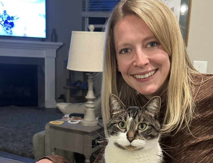 ENT provider Malorie VanWinkle smiles at camera with cat on her lap