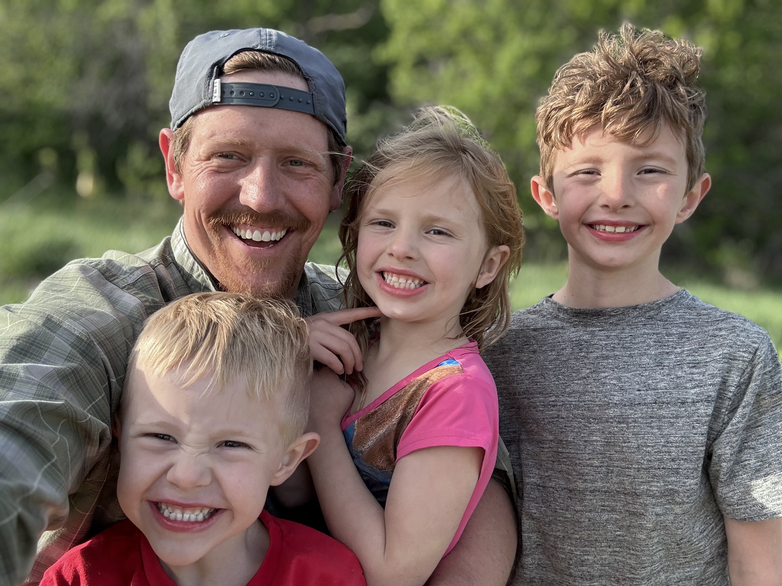 Dr. Clayton Wagner and his three kids smile together outside