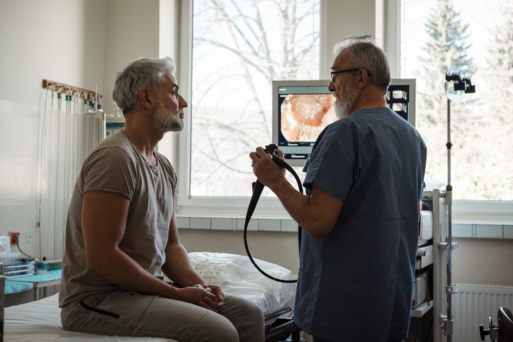 Man discussing colonoscopy with doctor