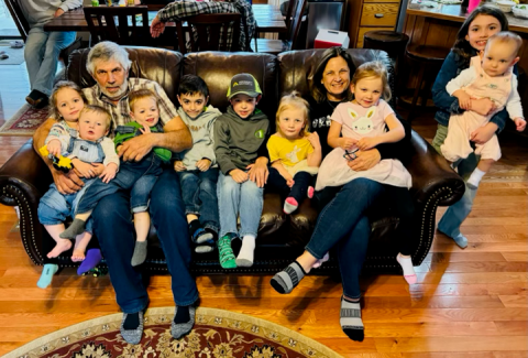 Certified nurse practitioner Chris Werner poses with her husband and nine grandchildren.