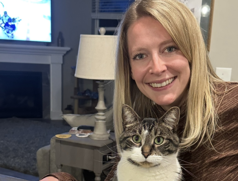 ENT provider Malorie VanWinkle smiles at camera with cat on her lap