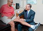 doctor examining a man's knee